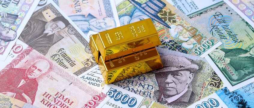 Icelandic krona money bills and gold bullion bars. Iceland cash bills of ISK currency close up