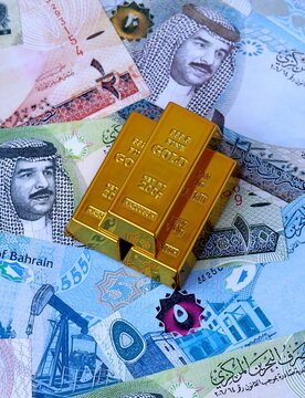 Bahraini dinar money bills and gold bullion bars. Bahrain cash bills of BHD currency close up