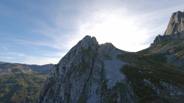 Dramatic aerial flight over the rugged limestone peaks of Pico Torres in Asturias, Spain. Captures the authentic beauty of the Cantabrian Mountains during golden hour for travel and wellness content.