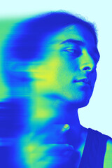 Fototapeta premium Young man looking aside in studio with thoughtful gaze and blue green motion blur effect. Individuality, creative portfolios concept.