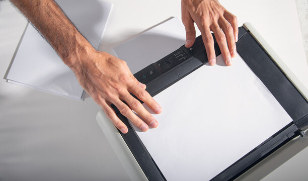 Man copying and scanning documents in office.