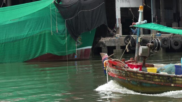 Wooden Fishing Boat Sailing Through Port in Thailand