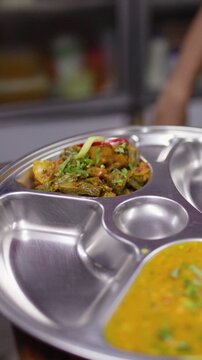 Chef Garnishing Traditional Indian Thali Platter in Restaurant Kitchen