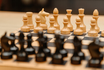 playing chess, black and white chess pieces are placed in rows on chessboard before game beginning © Anton Pentegov