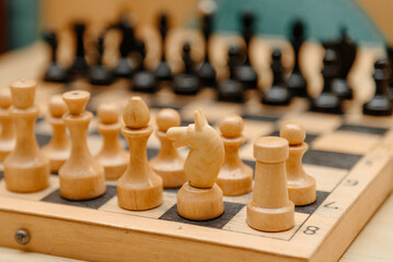 playing chess, black and white chess pieces are placed in rows on chessboard before game beginning © Anton Pentegov