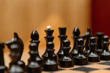playing chess, black chess pieces are placed in rows on black and white chessboard before game beginning © Anton Pentegov