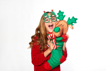 Excited teen girl in party glasses holding Christmas stocking with plush reindeer © cenchild