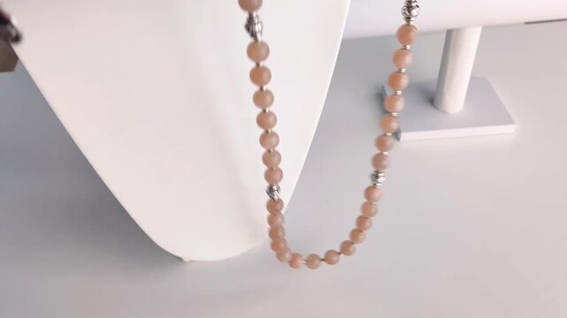 Elegant tiered natural sunstone gemstone necklace featuring sparkling crystal beads and polished silver hardware showcased on a white display bust
