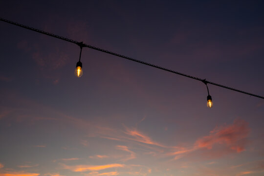 String lights hanging against a colorful sky during Halloween