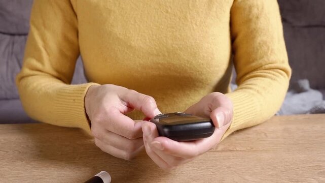 Woman measuring blood sugar level with a glucometer