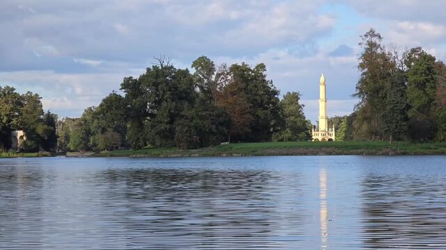 View of historic Lednice Minaret across lake in autumn park