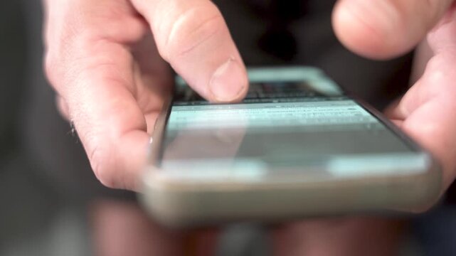 close up of hands doing infinite scrolling on mobile phone, concept of phone and social media addiction, doom scrolling