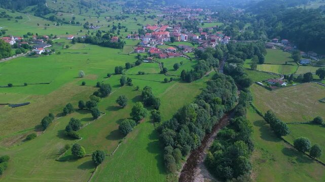 Aerial drone view of the summer countryside surrounding the village of Villacarriedo in the Pasiegos Valleys, Cantabria, Spain, Europe