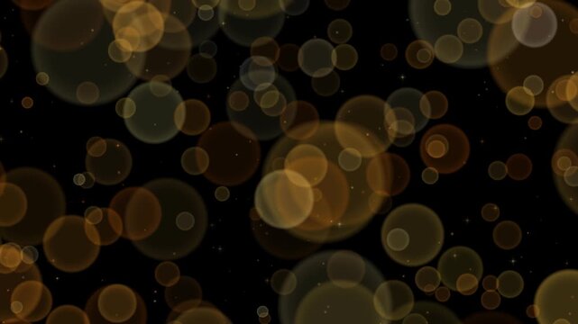 Gold bokeh lights drifting across a black background as large defocused circles overlap in layers of depth with sharp twinkling sparkles scattered between them