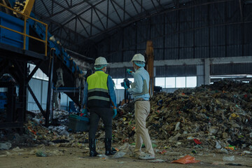 Fototapeta premium environmental engineers inspecting organic waste pile in waste to energy power plant.