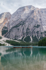 Rowing boats floating on turquoise alpine water of Lago di Braies beneath Croda del Becco © WeiChun