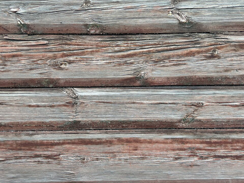 Weathered wooden planks close-up with deep grain knots, cracked timber, and faded rustic paint texture for outdoor background