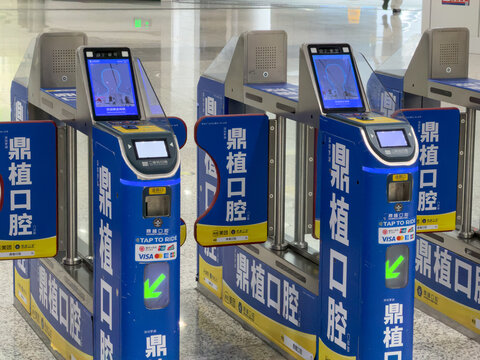 Shenzhen, China - September 21, 2026: Close up of blue fare gates with scanners and dental ads