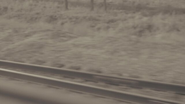 Railway track moving fast seen from passenger train window