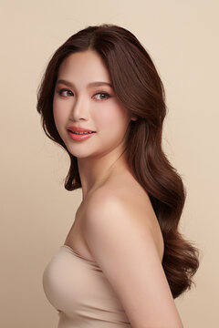 A beautiful young Asian woman with clean, fresh skin against a beige background. Skincare, facial treatment, cosmetology, beauty, and spa. An elegant portrait of an Asian woman.