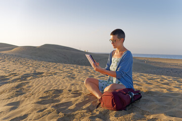 Woman using tablet during outdoor work break on sand dunes © Pawel