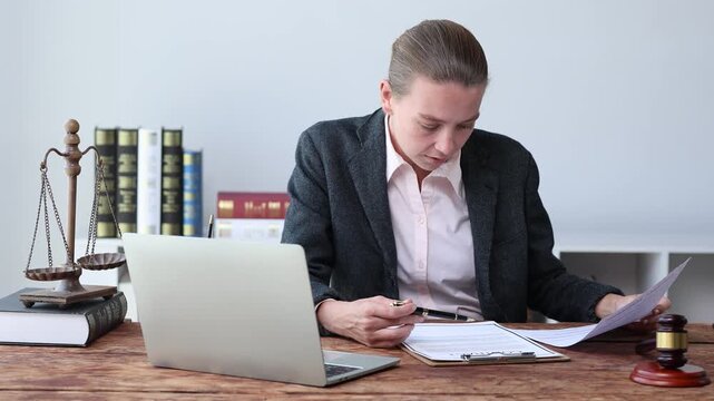Professional lawyer working at office desk reviewing legal documents, lawsuit contract, and consulting with client