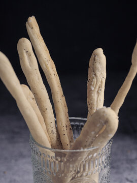 Italian grissini breadsticks in a glass on baking paper
