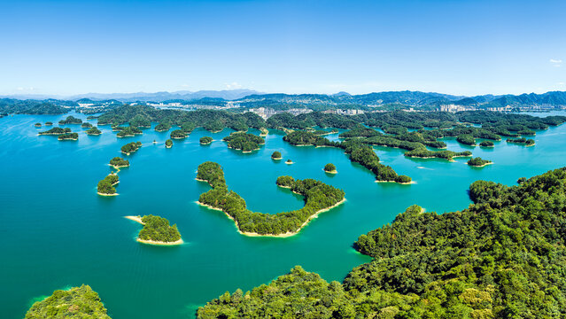 Lush green forested islands dotting turquoise waters of Thousand Island Lake in Hangzhou, Zhejiang, China.