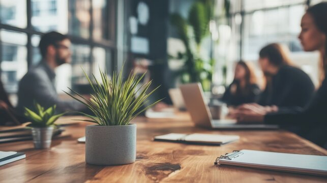 Business Meeting with Blurred Colleagues and Potted Plant