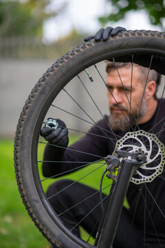 Man repairing bicycle wheel with disc brake