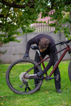 Man Fixing Mountain Bike in Backyard