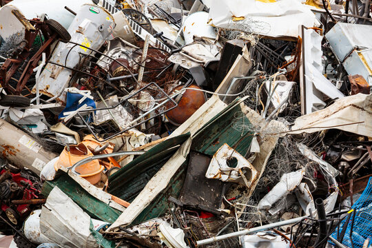 Large pile of washing machines, refrigerators and metal heap in a recycling plant, in a heap.