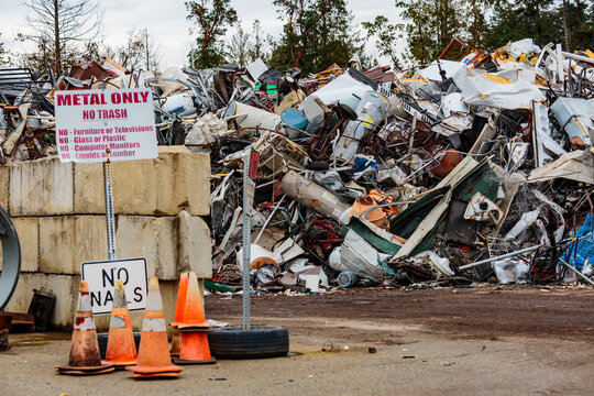 Metal Only sign, a large pile of washing machines, refrigerators and metal heap in a recycling plant, in a heap.