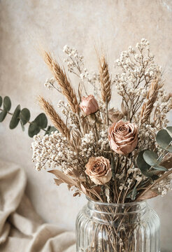 Elegant dried flower arrangement in glass vase with soft rose blooms