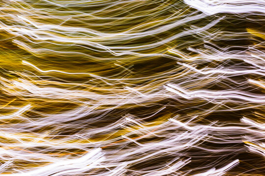 Blurred lights, city lights, an abstract light pattern of parallel waves shapes and lines.