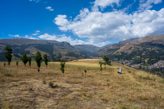 Huancayo, Jun&iacute;n, Per&uacute; : A photographer observes the Andean landscape from farmland above Huancayo in central Peru. Surrounded by dry grassland, young trees and cultivated fields.
