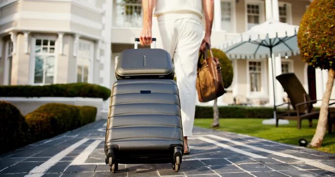 Holiday, entry or legs at resort with suitcase, travel reservation or accommodation for getaway trip. Walking, back or man in lodge with luggage, hotel booking or guest arrival for summer vacation.