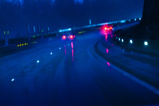 Limited visibility, driving conditions on the wet surface of Interstate 90 through the Cascade Mountains, elevated view.