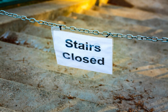 Stairs Closed sign on a chain across marble steps.