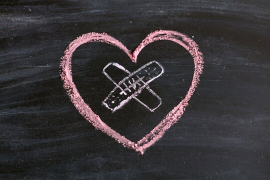 The Heart with Bandage Illustration on a Chalkboard Surface in Soft Pink