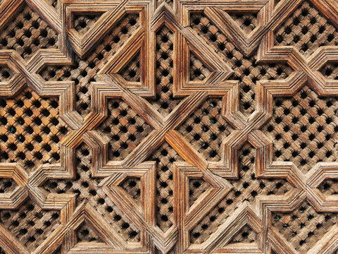 Lattice Woodwork, geometric carvings and patterns in a fretwork screen in the historic Medresa El Bouanania.