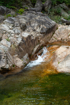 Crystal clear mountain stream water flowing over granite rocks and mini waterfall into green natural pool in Seoraksan National Park, scenic nature landscape wallpaper and summer travel background.