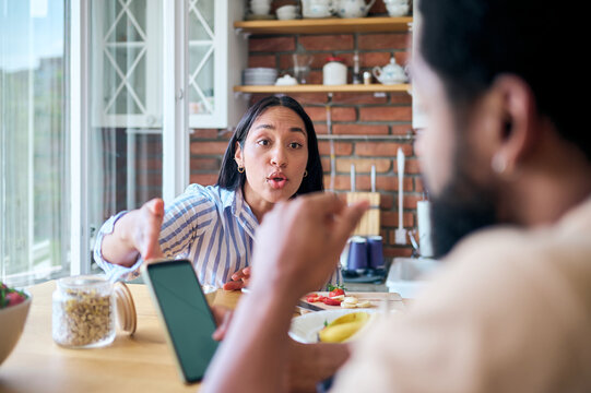 Angry woman confronting partner during an argument over mobile phone