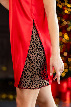 Close-up detail of red silk nightgown with sheer leopard mesh insert