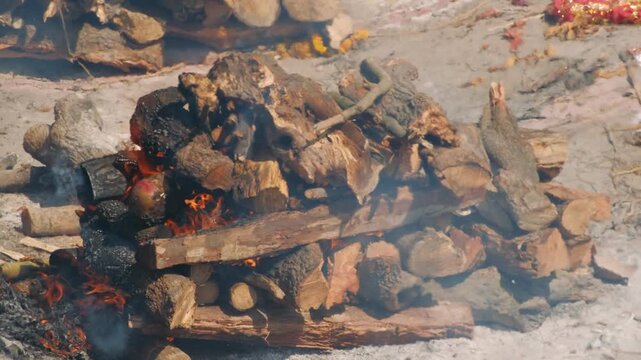 Traditional hindu funeral pyre burning during cremation ceremony at manikarnika ghat in varanasi, india