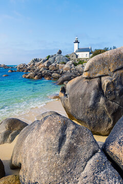 Vertical view of Phare de Pontusval lighthouse standing on granite rock coast with turquoise ocean water in Kerlouan Brittany France