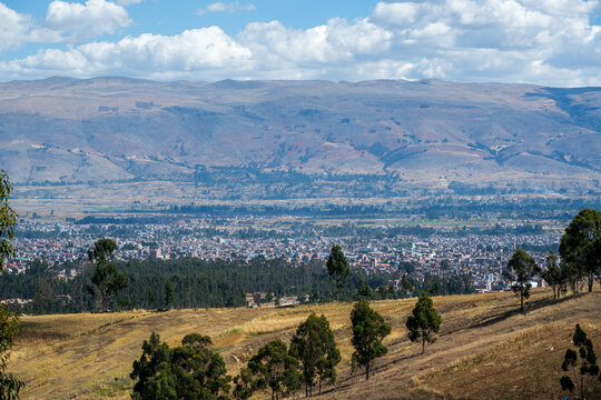 Huancayo spreads across the Mantaro Valley beneath the high Andes in Jun&iacute;n, Peru. Elevated panoramic landscape showing the dense Andean city beyond agricultural fields.