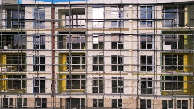 Building facade thermal insulation work with scaffolding on apartment house