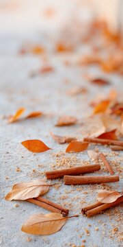 Warm autumn composition with cinnamon sticks and dry leaves on pastel background