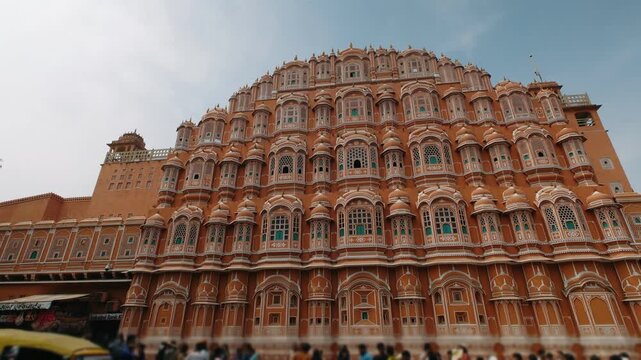 Hawa mahal palace of the winds architectural facade with tourists walking in jaipur, india on a sunny day